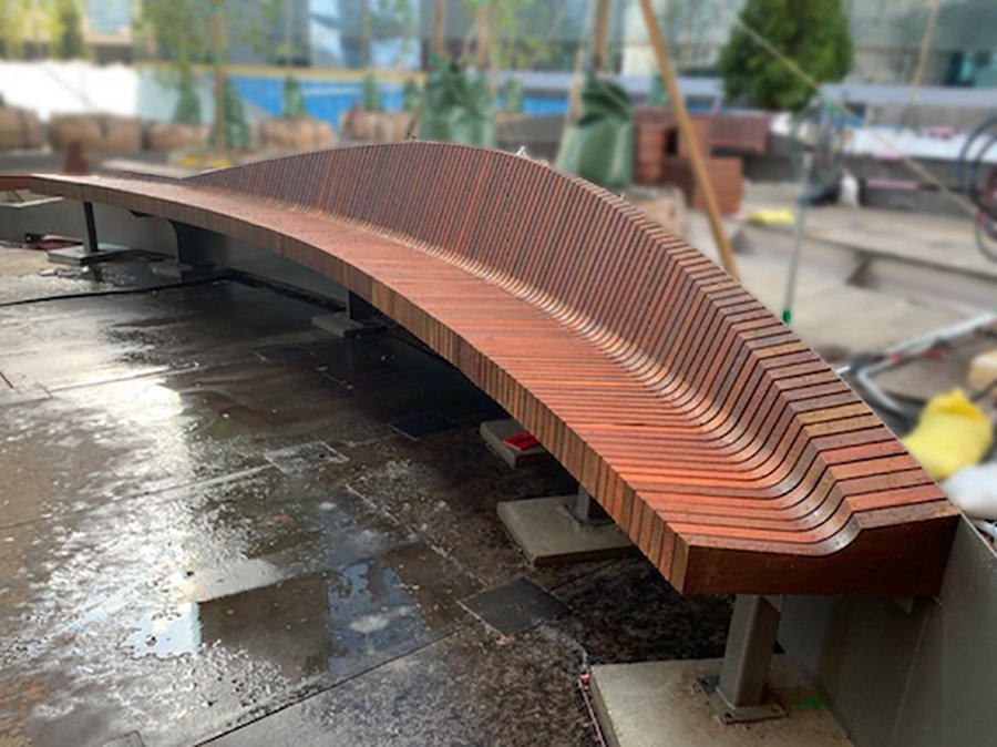 Sculpted Ipe wood benches on a New York City rooftop deck — showing Ipe's consistent olive-brown coloring and tight grain suitable for architectural applications