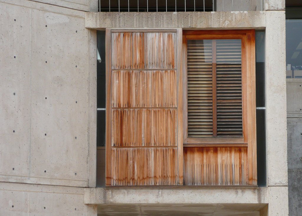 A wood window opening set into a concrete wall, where the trim meets masonry