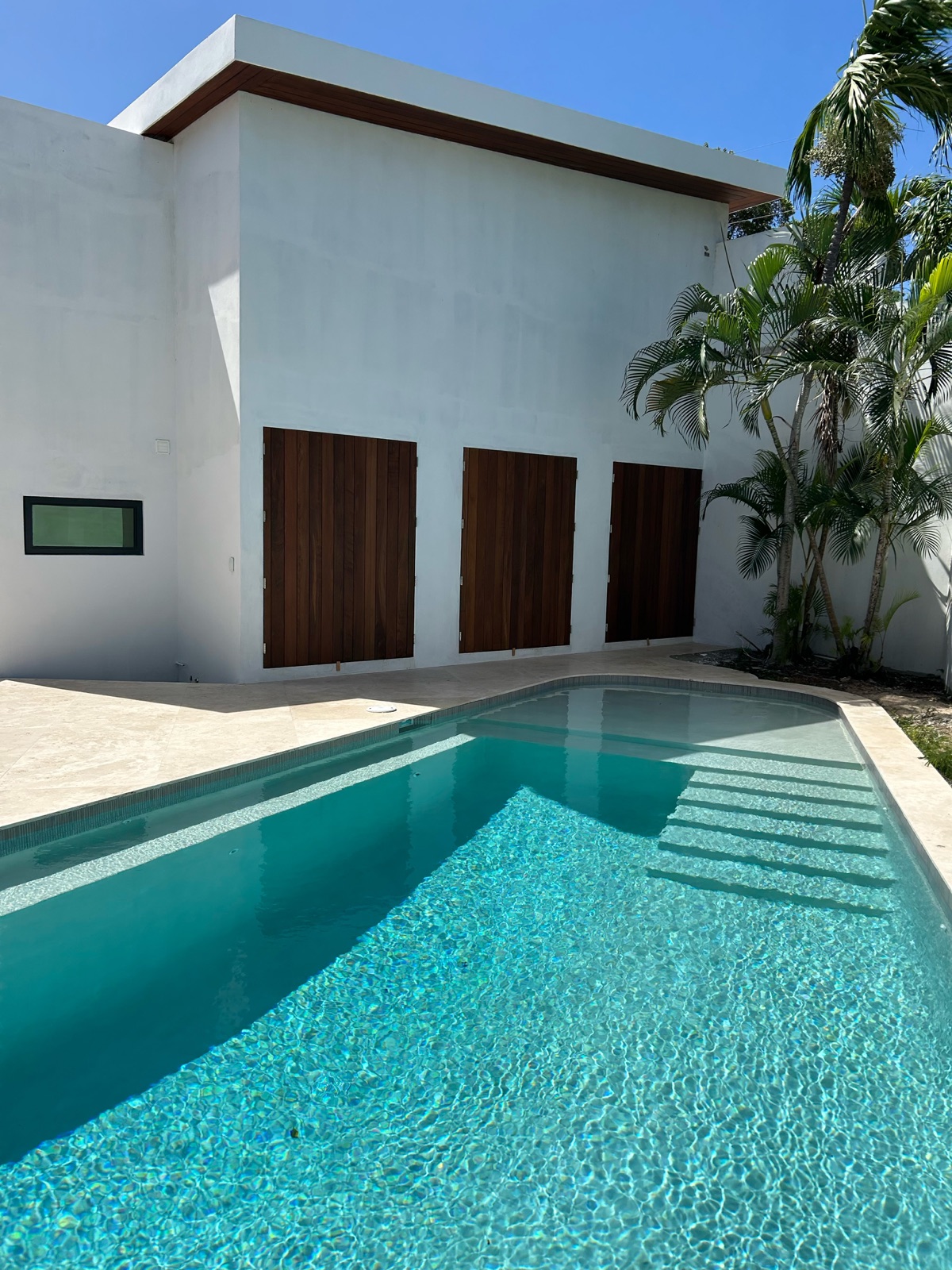 Tropical hardwood decking and vertical screening at a poolside patio