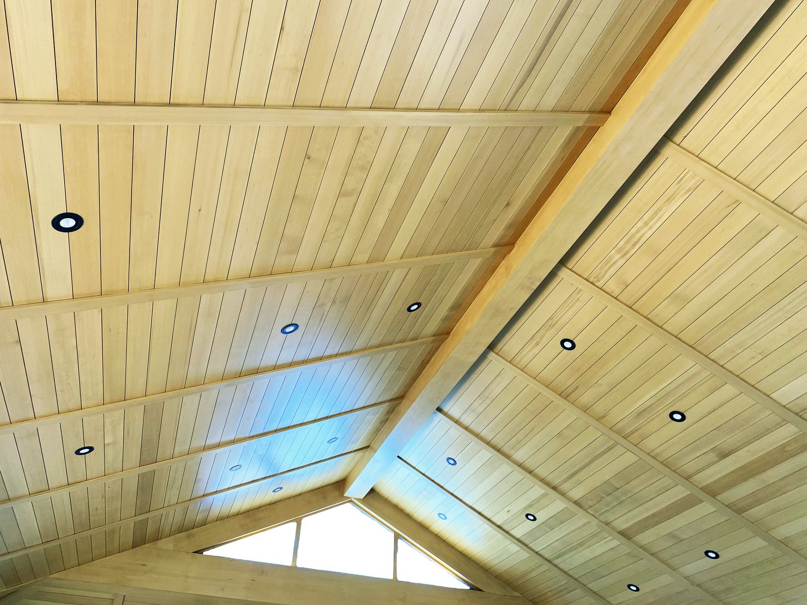Ceiling boards running to a ridge with lighting set flush