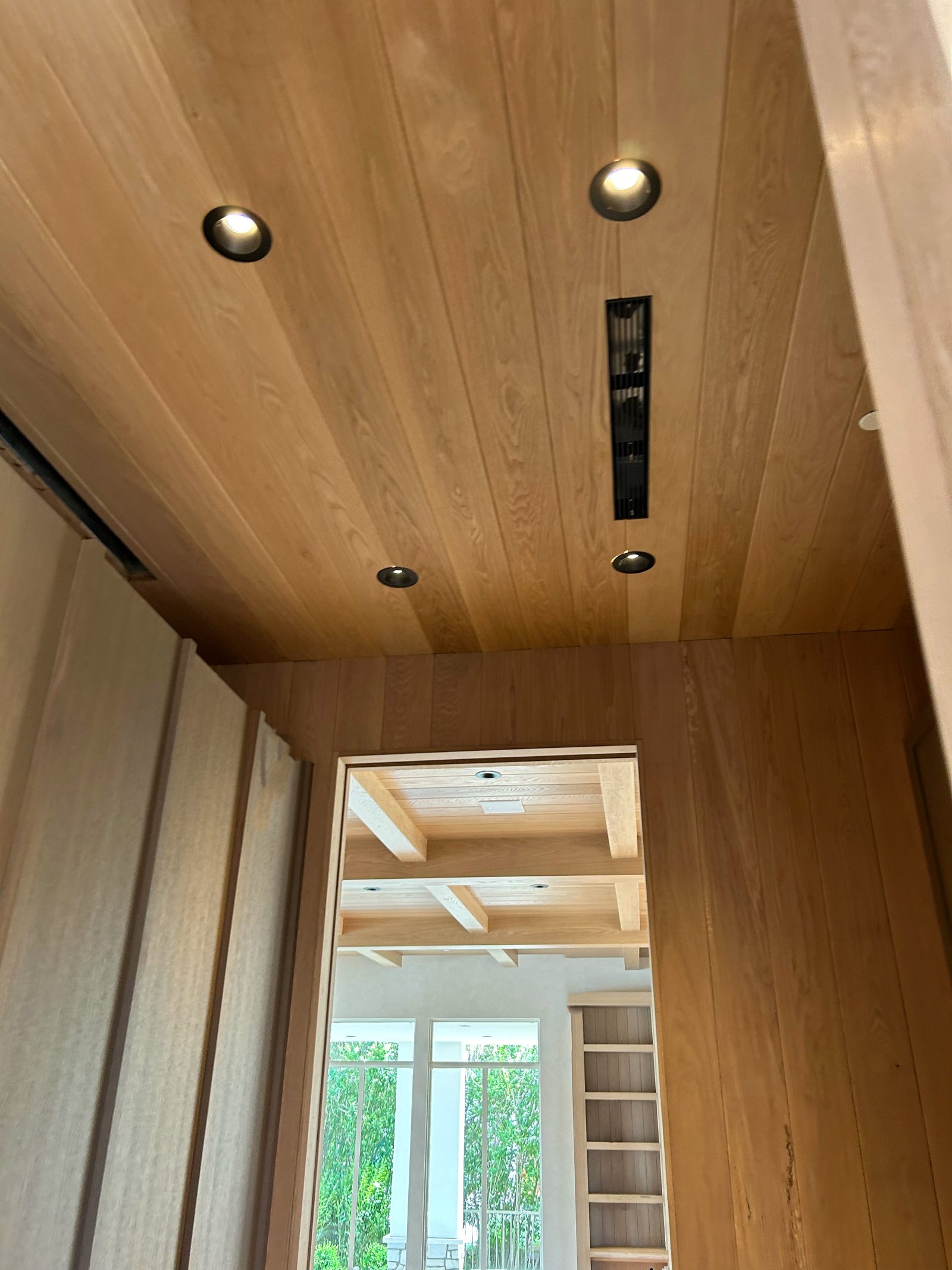 White Oak ceiling and wall meeting, with a fixture recessed into the boards