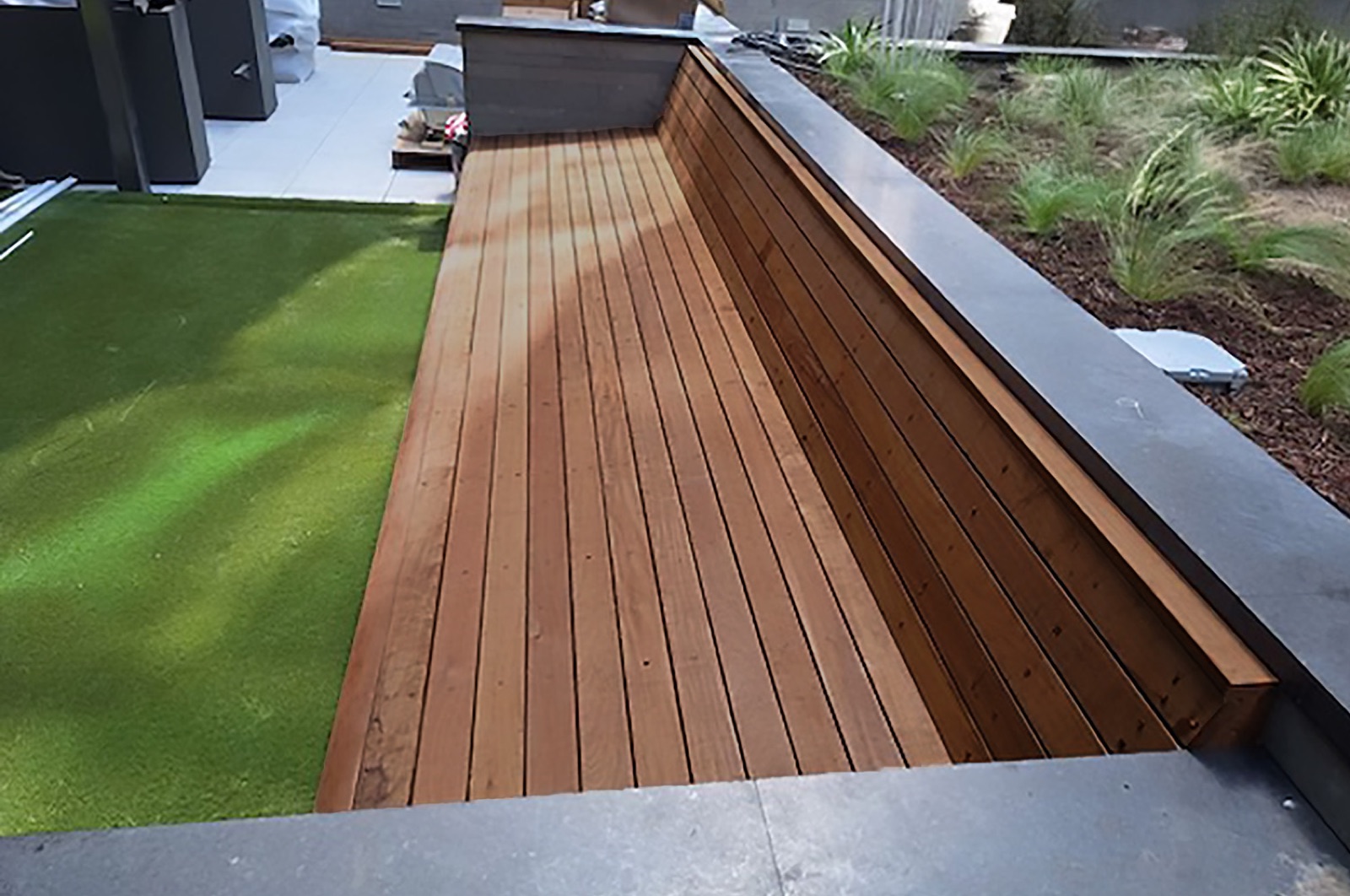 Curved tropical hardwood seating on a finished deck