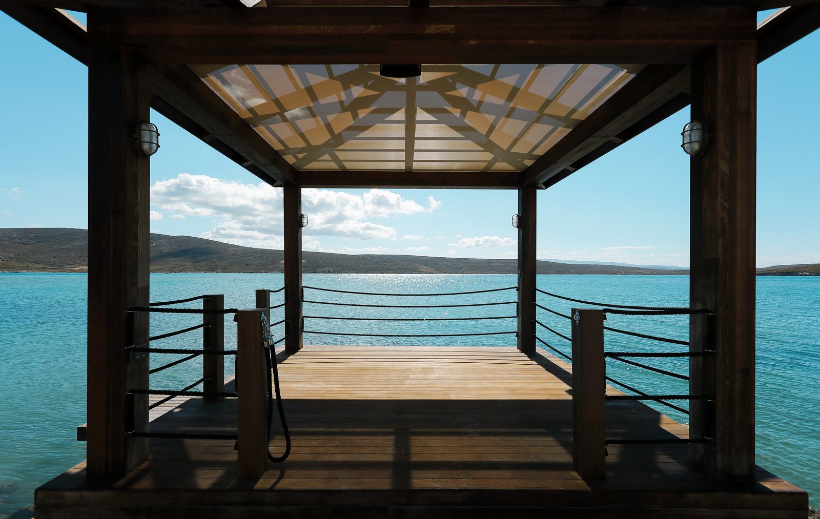 Covered structure over water, carried on posts with an open roof frame