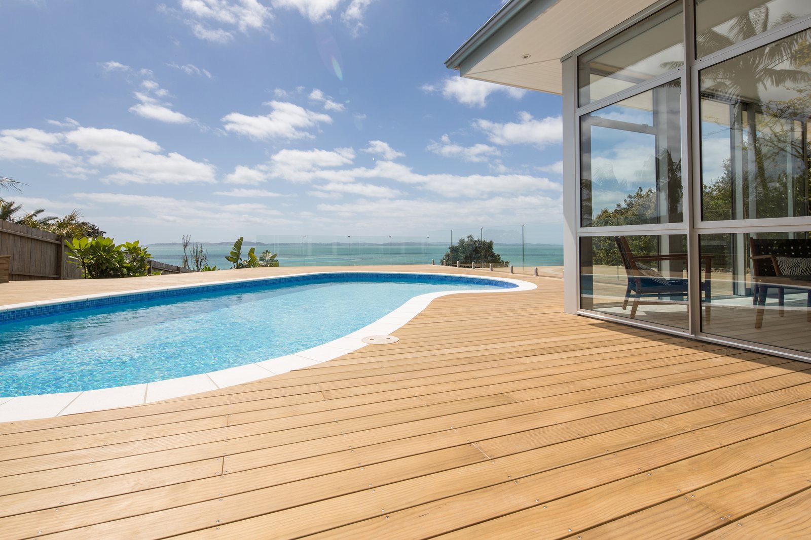 Modified decking in a light finish beside a pool