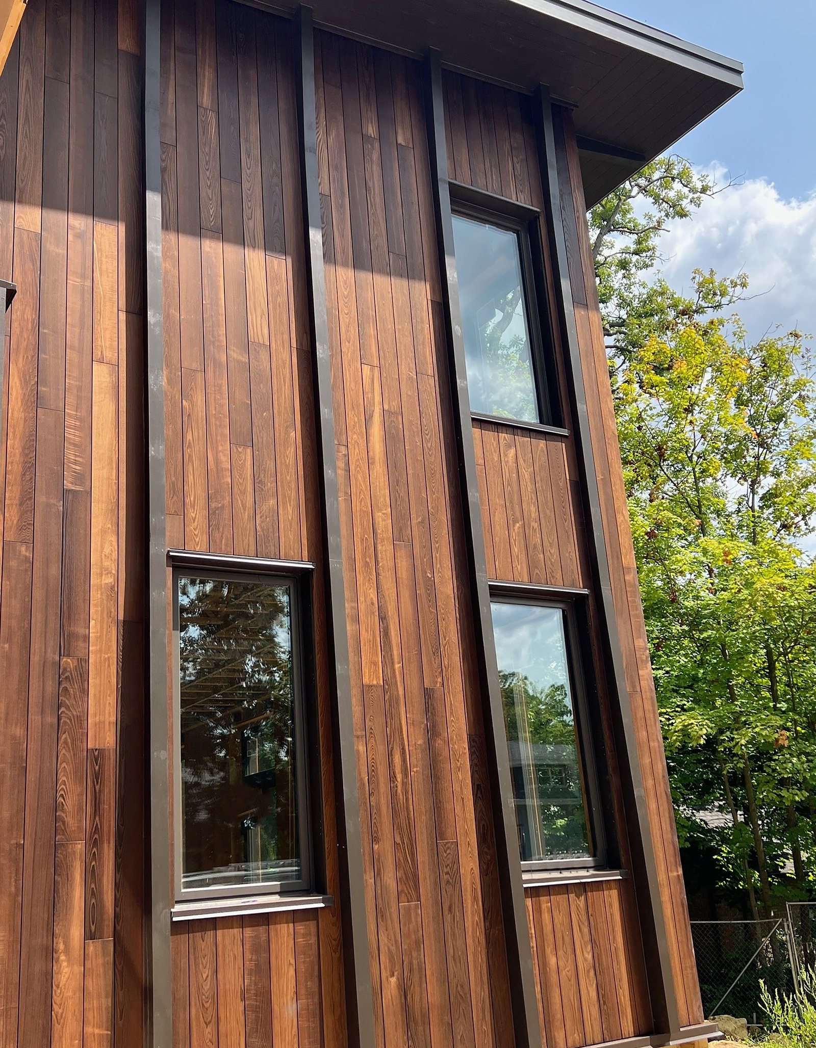 Vertical cladding boards carried up a tall elevation