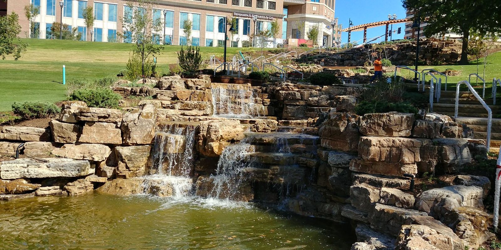 Timber structure set above a water feature in a planted garden