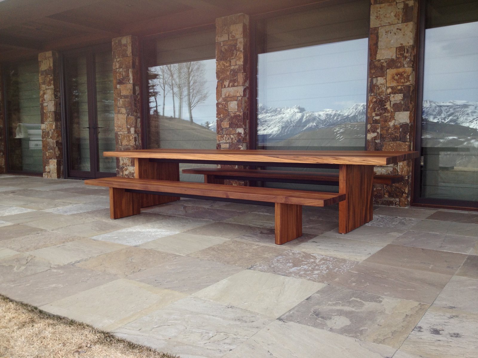 A teak table and bench on a terrace, the same stock used ashore