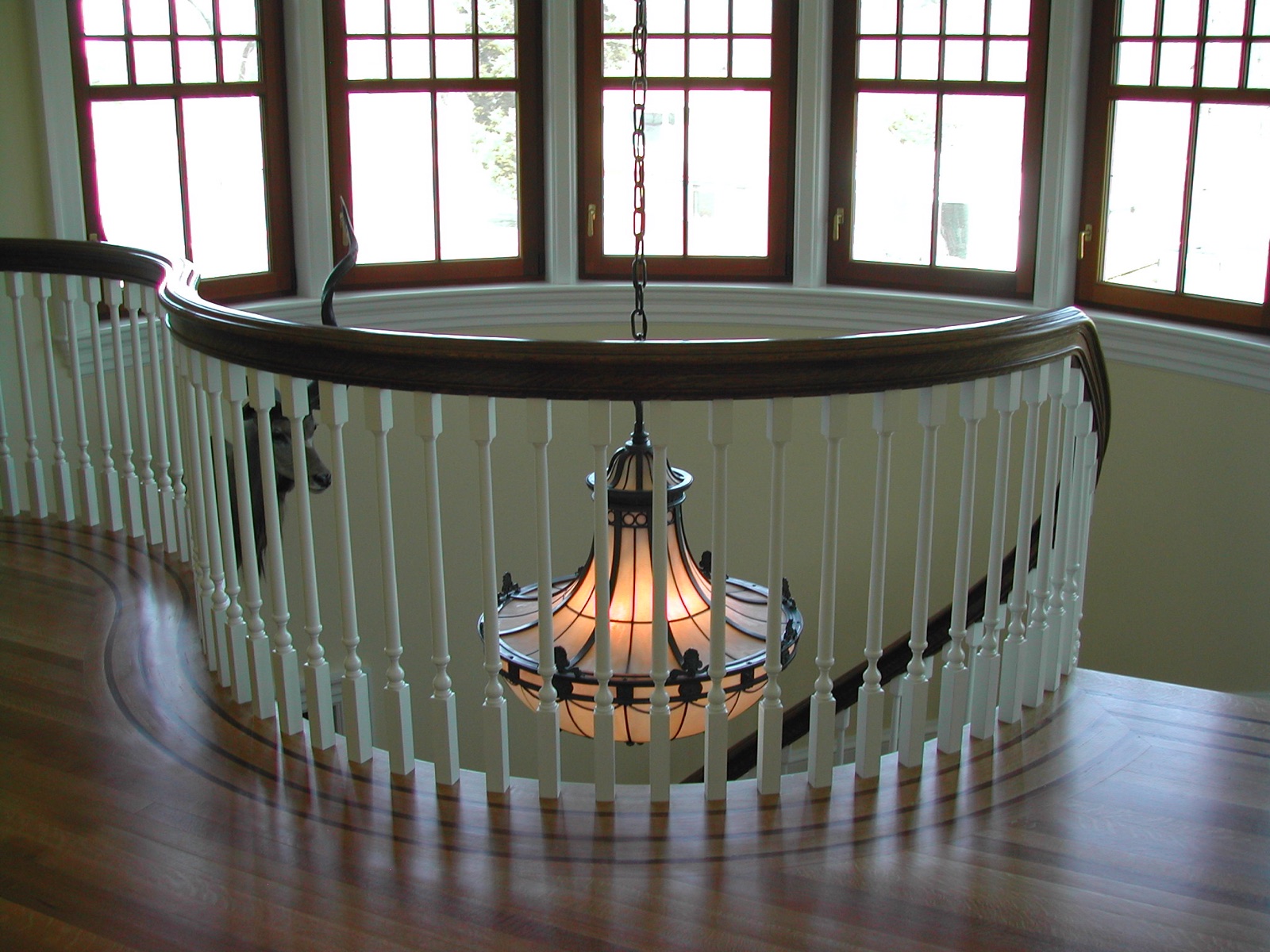 Curved handrail carried around a stair opening
