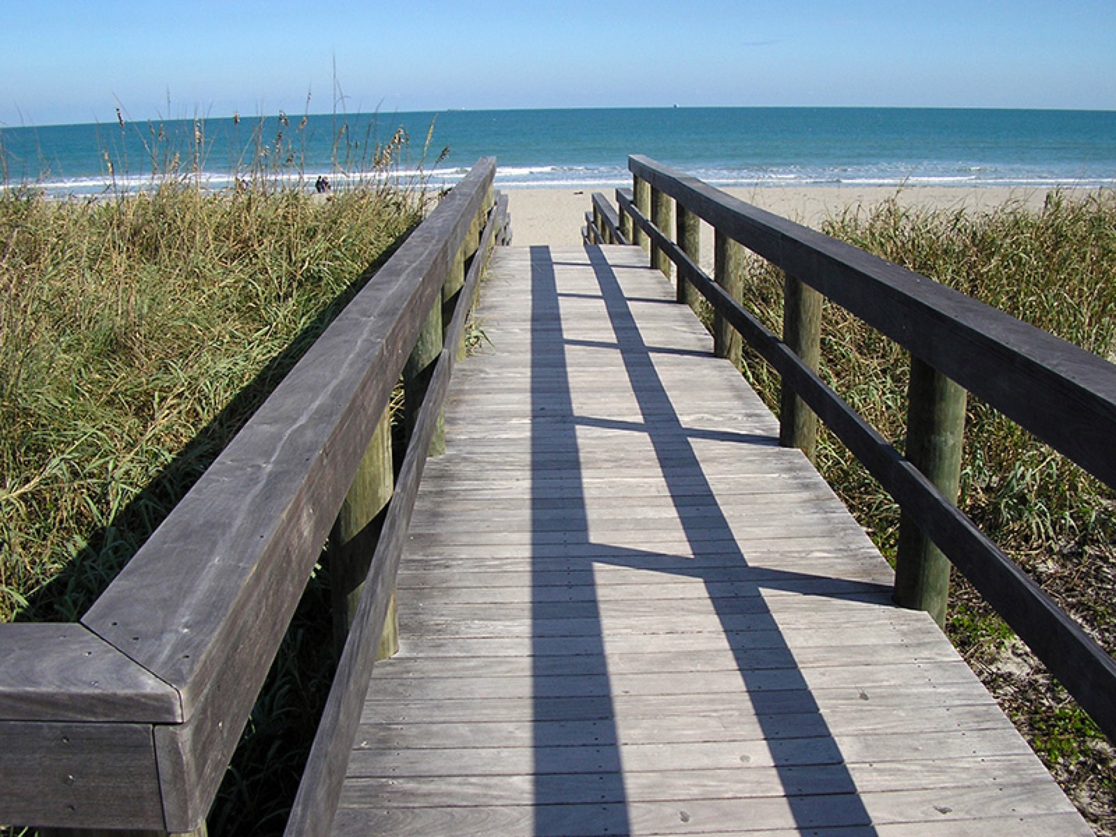 Tropical hardwood pier walkway to the beach