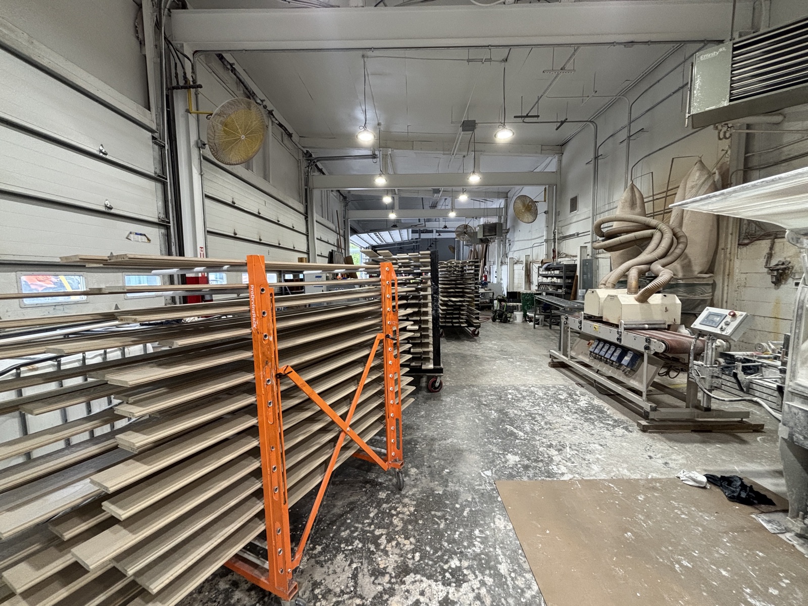Racks of primed millwork staged on the shop floor