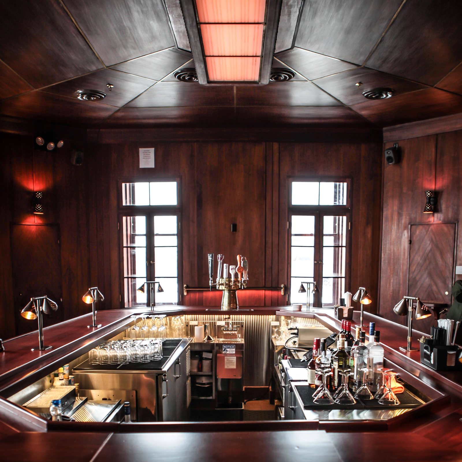 A bar interior in teak, the sightline a reviewer walks at handover