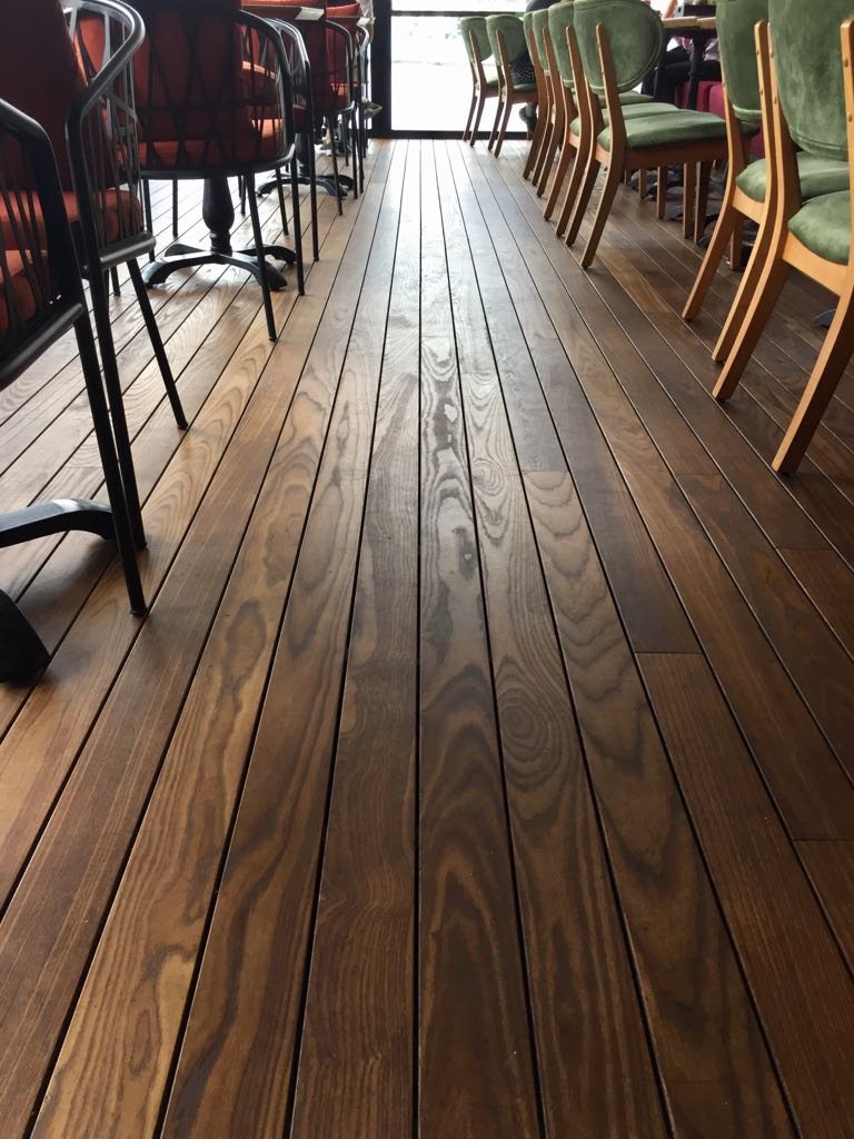 Thermally modified ash flooring running through an interior